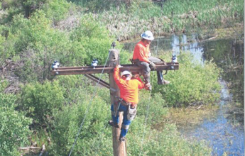 two linemen working on transmission lines